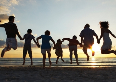 Family jumping on the beach at sunset